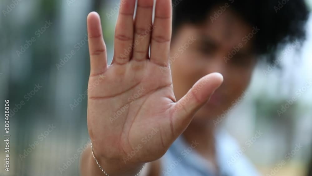 Mixed race woman saying STOP with hand, showing restriction Mixed race woman saying STOP with hand, showing restriction