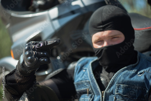 A motor biker is showing a middle finger close up.