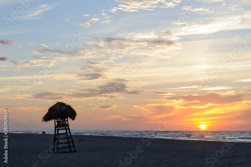 Thatched lifeguard tower on a tropical beach at sunset photo