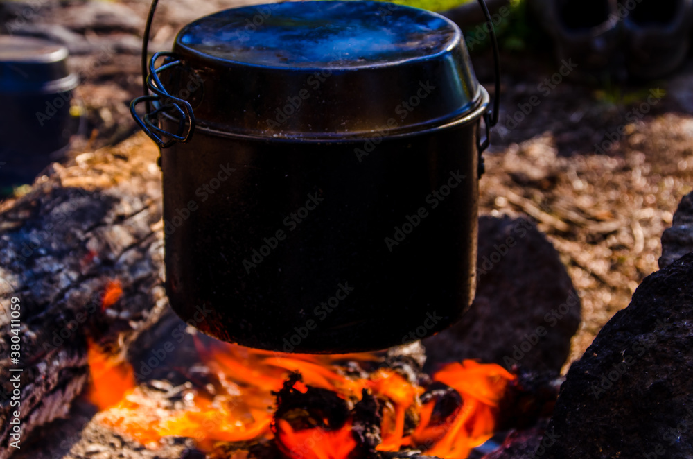 fire burns in the campaign. pot of tea by the fire. fire burns in the campaign. pot of tea by the fire.