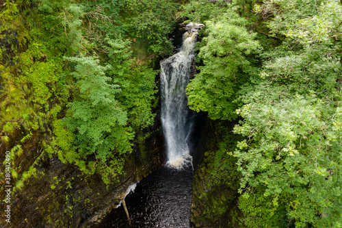 Tall waterfall in a narrow canyon surrounded by green foliage  Sgwd Einion Gam  Waterfall Country  Wales 