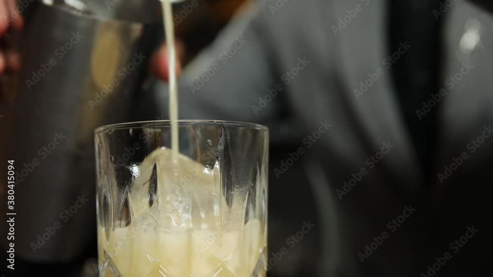The bartender prepares an alcoholic cocktail with ice. Macro photography The bartender prepares an alcoholic cocktail with ice. Macro photography