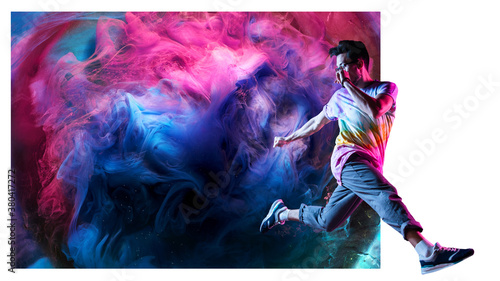 Professional break dancer posing in motion, practicing modern hip-hop dance against the background of abstract colorful smoke