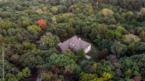 Woods at sunset aerial with large home