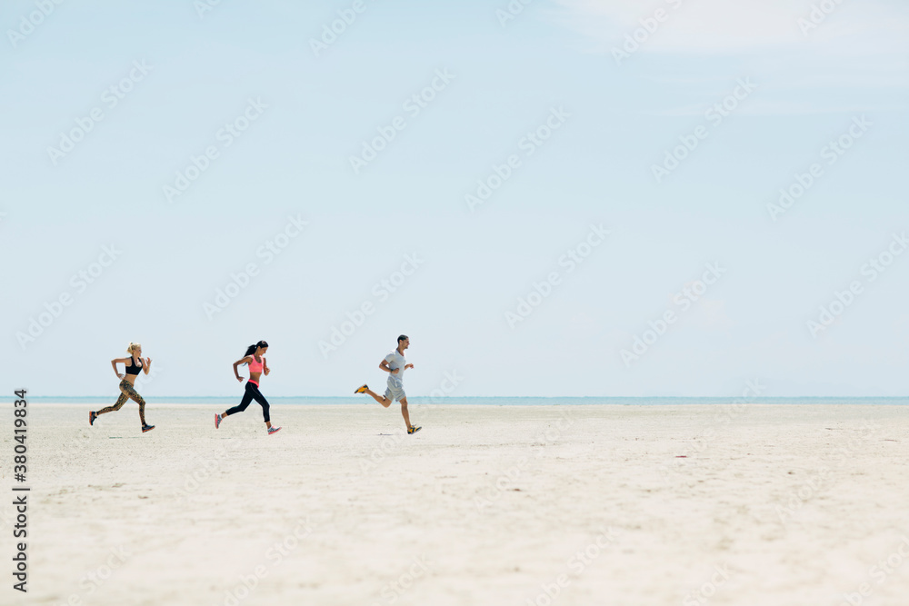 Group of People Jogging on the Beach