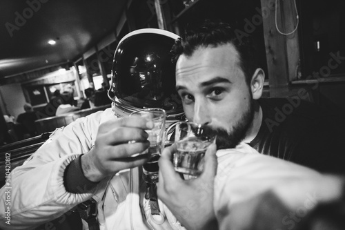 Two friends enjoying alcohol one in a spaceman costume photo