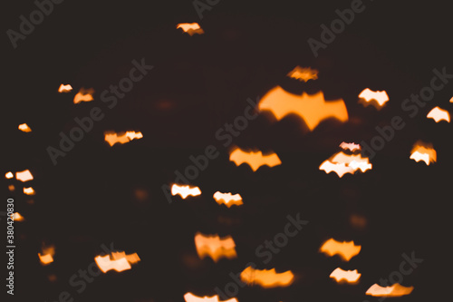 defocused bokeh gold lights in shape of bats for halloween background - holidays  decoration and party concept