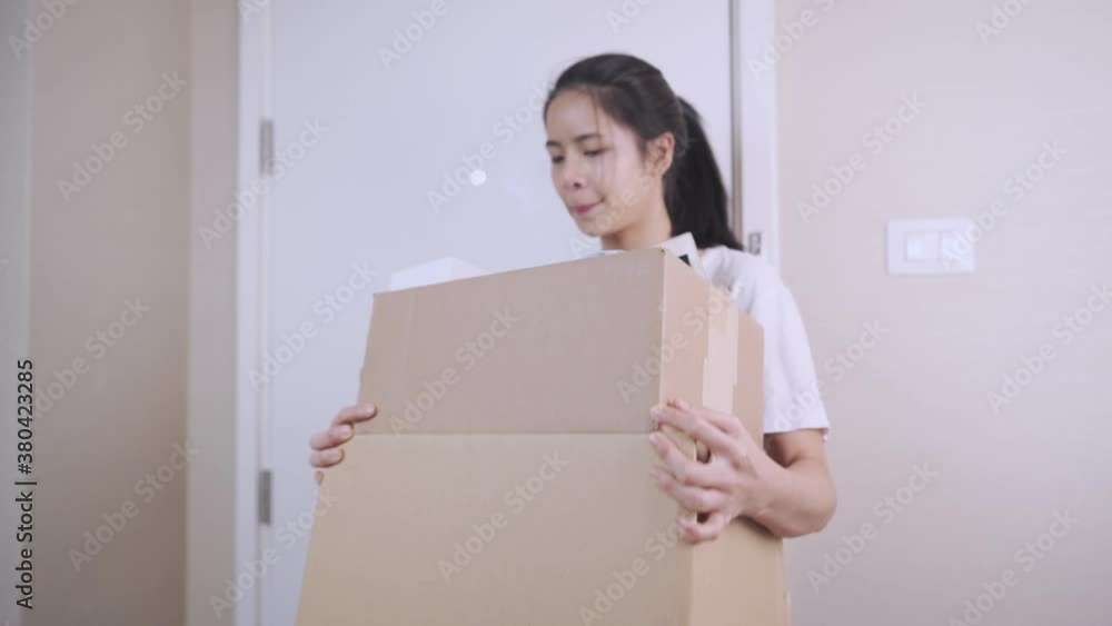 Young Asian lady carrying carton box entering new apartment, brown carton cardboard box container, house loan, Relocation moving into new room, storage space shipment delivery, single woman Young Asian lady carrying carton box entering new apartment, brown carton cardboard box container, house loan, Relocation moving into new room, storage space shipment delivery, single woman