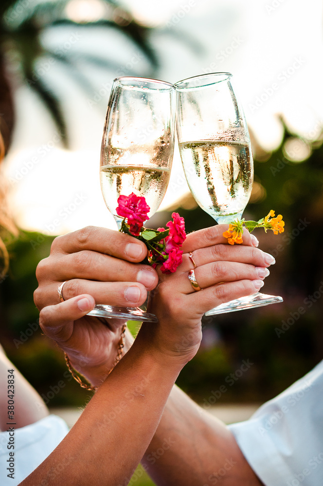 Woman's and man's hands are holding glasses with sparkling white wine. Wedding ceremony concept.	