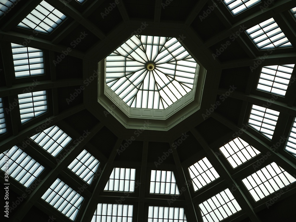 Looking up to an octagonal geometric glass window roof of a hall