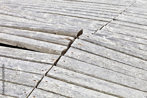 The surface of a wooden structure damaged by severe weather conditions. Old wooden planks surface texture. Surface made of weathered planks. Damaged Wooden surface made of antique boards.