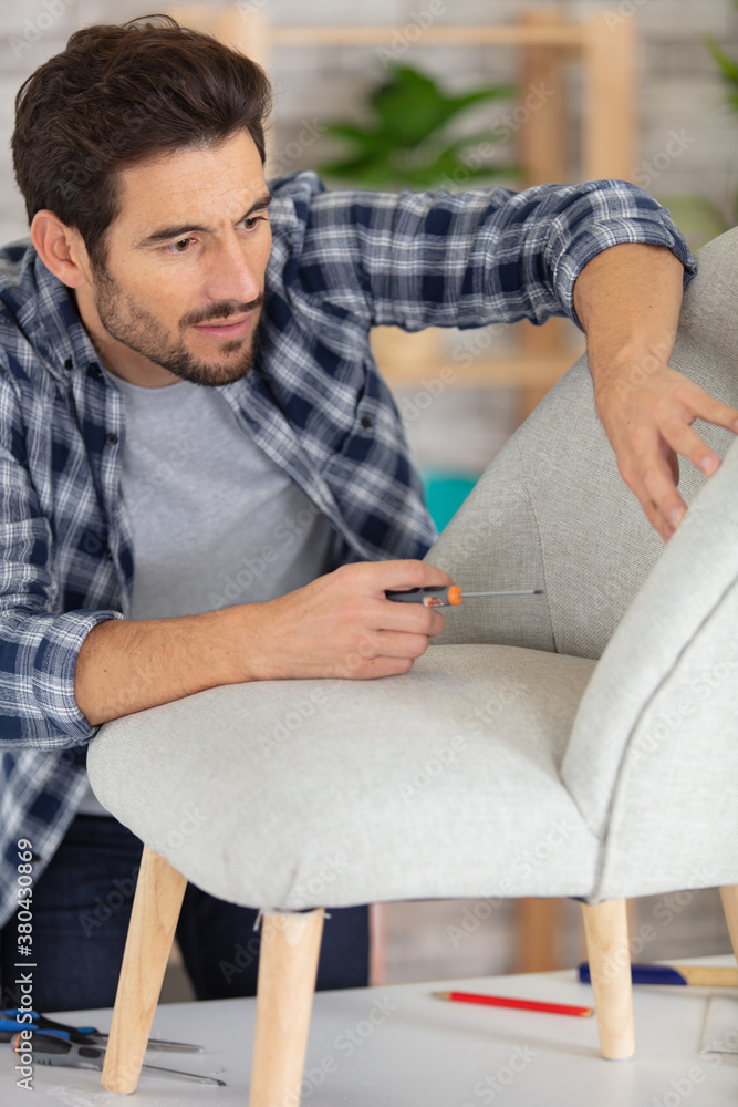 young male carpenter repairing a chair young male carpenter repairing a chair