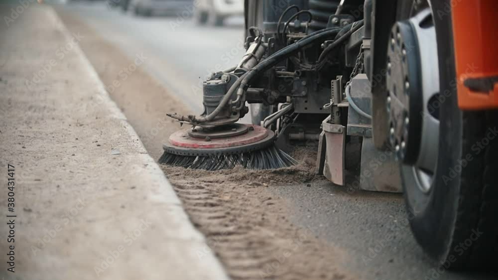 Big industrial machine levels concrete dust with a sweeper on the side of the road Big industrial machine levels concrete dust with a sweeper on the side of the road