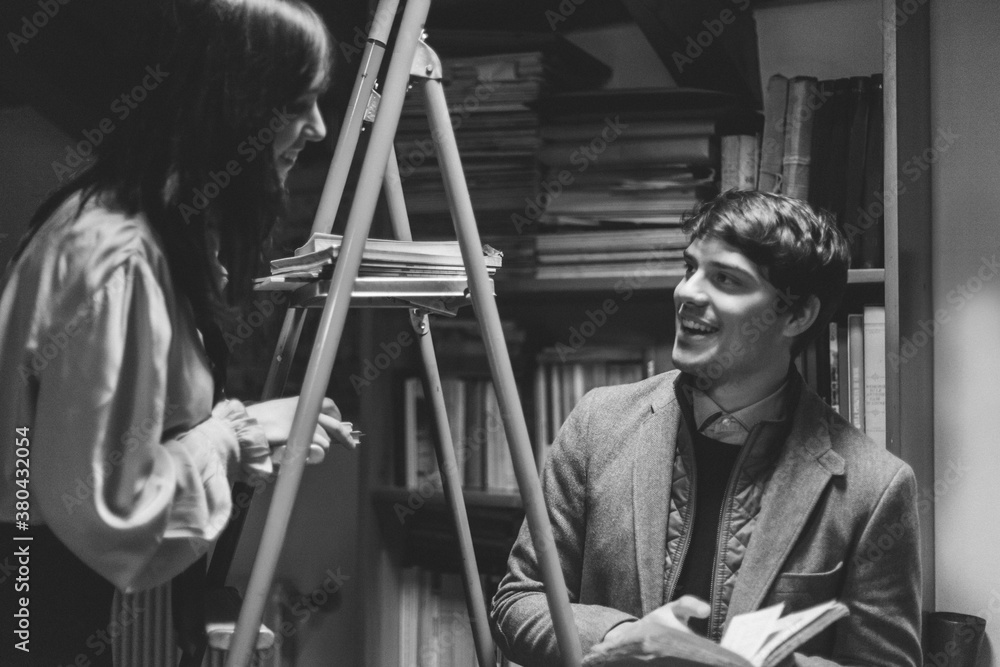 Young College Couple Talking into a Library Young College Couple Talking into a Library