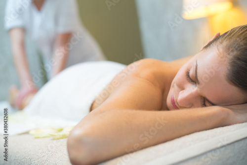 female enjoying relaxing back massage in cosmetology spa centre