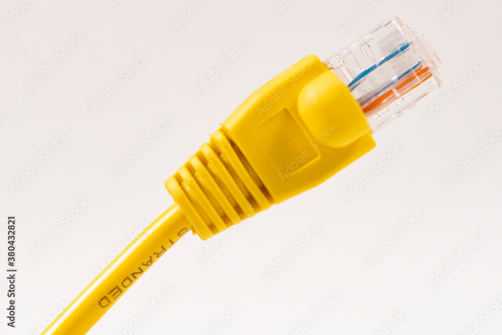Yellow Network Cable with molded RJ45 plug isolated against white background. Yellow Network Cable with molded RJ45 plug isolated against white background.