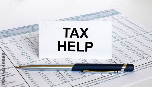 Text Tax Help on white card with blue metal pen on financial table