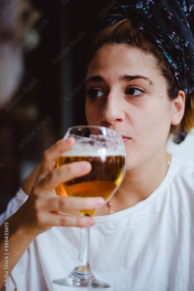 Blonde girl with turbant drinking a beer Blonde girl with turbant drinking a beer
