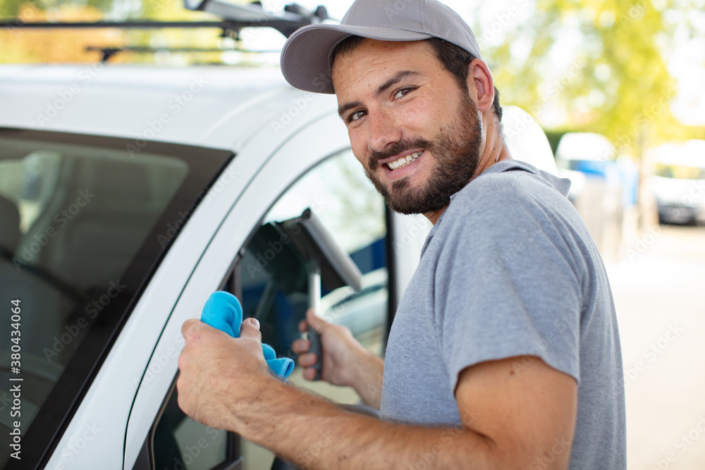 portrait of a young man cleaning his car portrait of a young man cleaning his car
