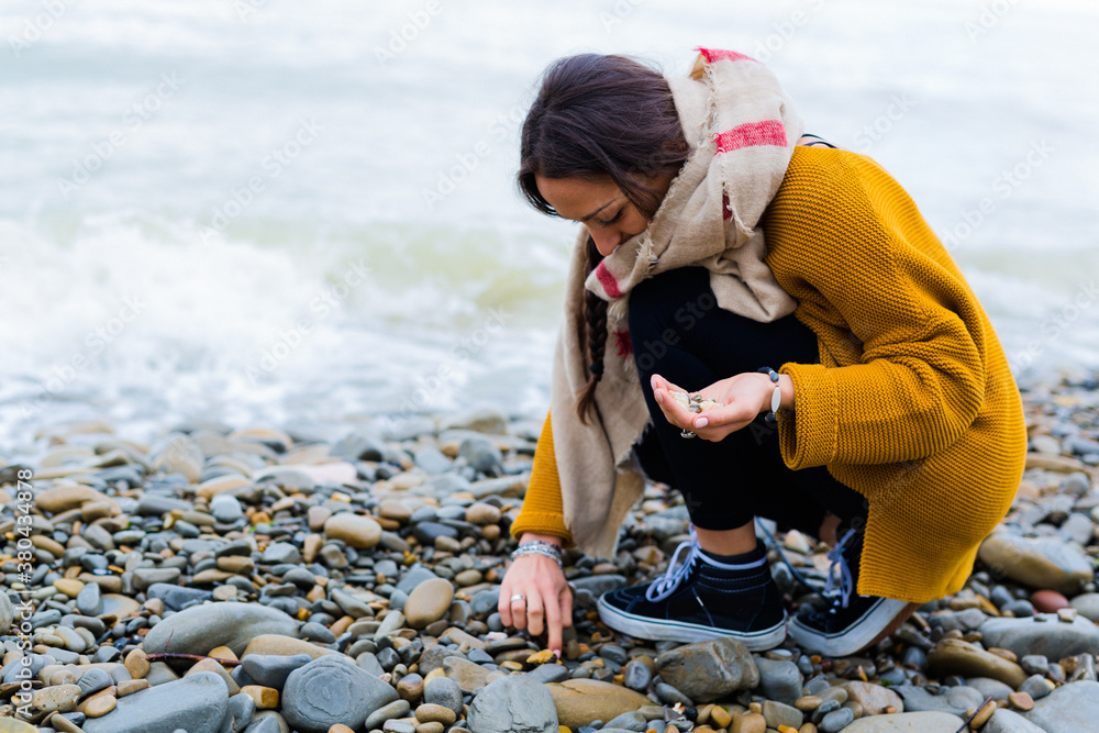Woman on the beach collecting shells Woman on the beach collecting shells