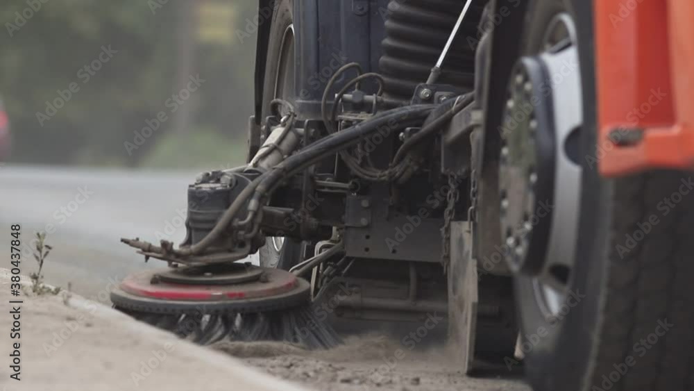 Industrial machine clears the asphalt out of dust with a sweeper Industrial machine clears the asphalt out of dust with a sweeper