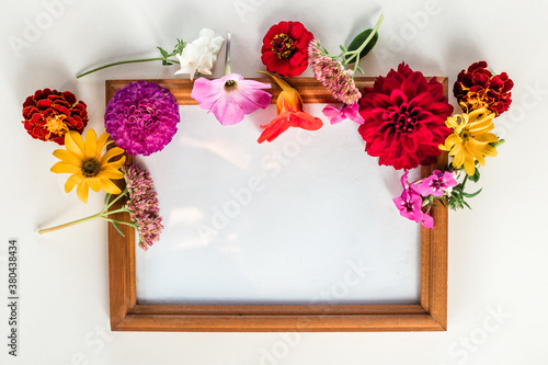 frame with bouquet of flowers on white background. Flat lay, top view, copy space