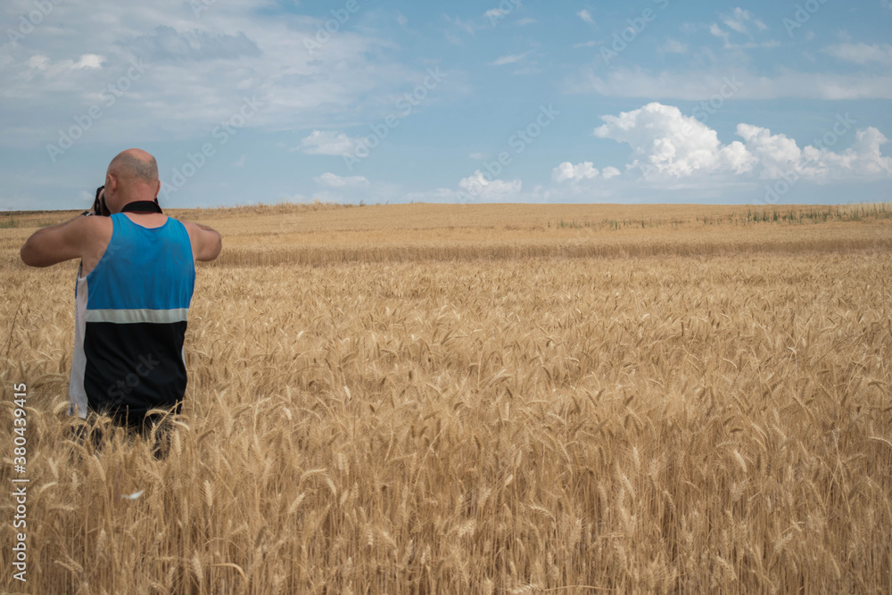 Photographer takes pictures in a wheat field.