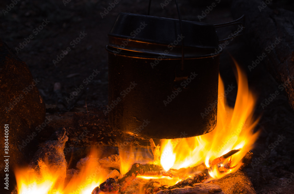 fire burns in the campaign. pot of tea by the fire. fire burns in the campaign. pot of tea by the fire.
