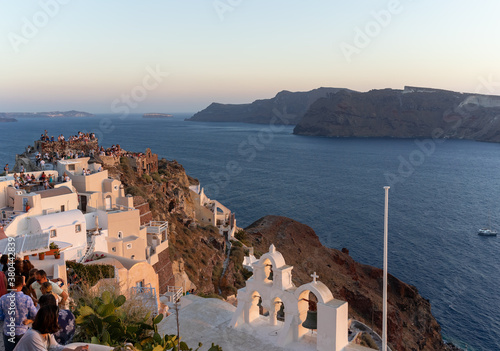Beautiful panoramic view from Oia to caldera and volcano at sunset. Picturesque natural background with copy space for text. Santorini island, Cyclades, Greece, Europe.