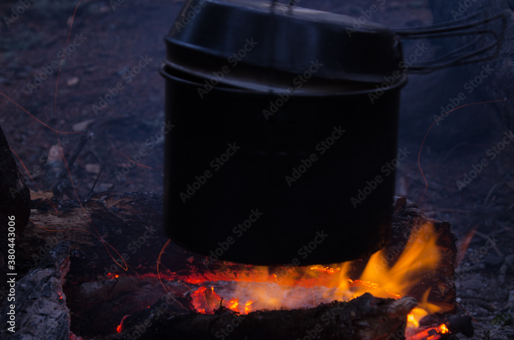fire burns in the campaign. pot of tea by the fire. fire burns in the campaign. pot of tea by the fire.