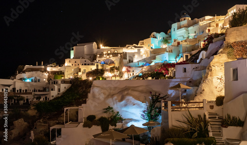 Night falling on the Greek village of Oia on the island of Santorini. typical orthodox church overhangs the village. beautiful sky with stars © mathilde