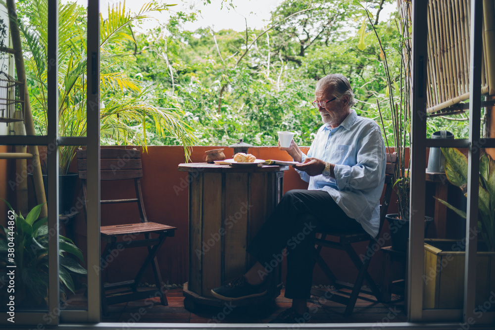 Senior Man Drinking Coffee and Reading Newspaper Senior Man Drinking Coffee and Reading Newspaper