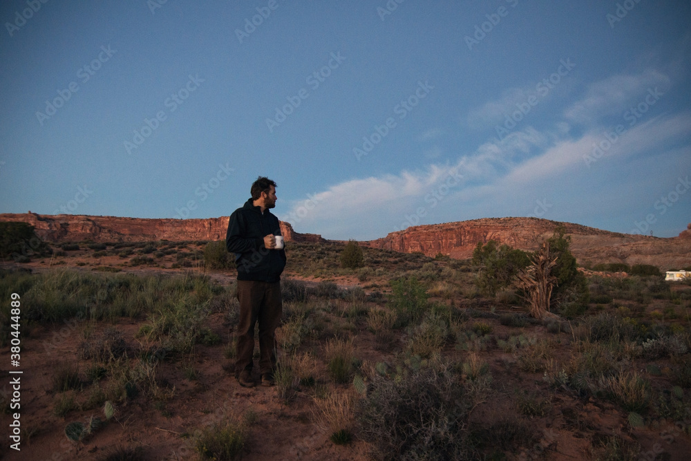 Man drinking coffee at sunrise in the Moab Desert Man drinking coffee at sunrise in the Moab Desert