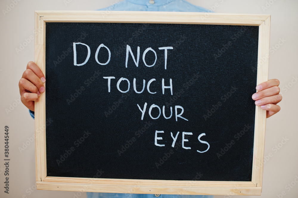 Do not touch your eyes. Coronavirus concept. Boy hold inscription on the board. Do not touch your eyes. Coronavirus concept. Boy hold inscription on the board.