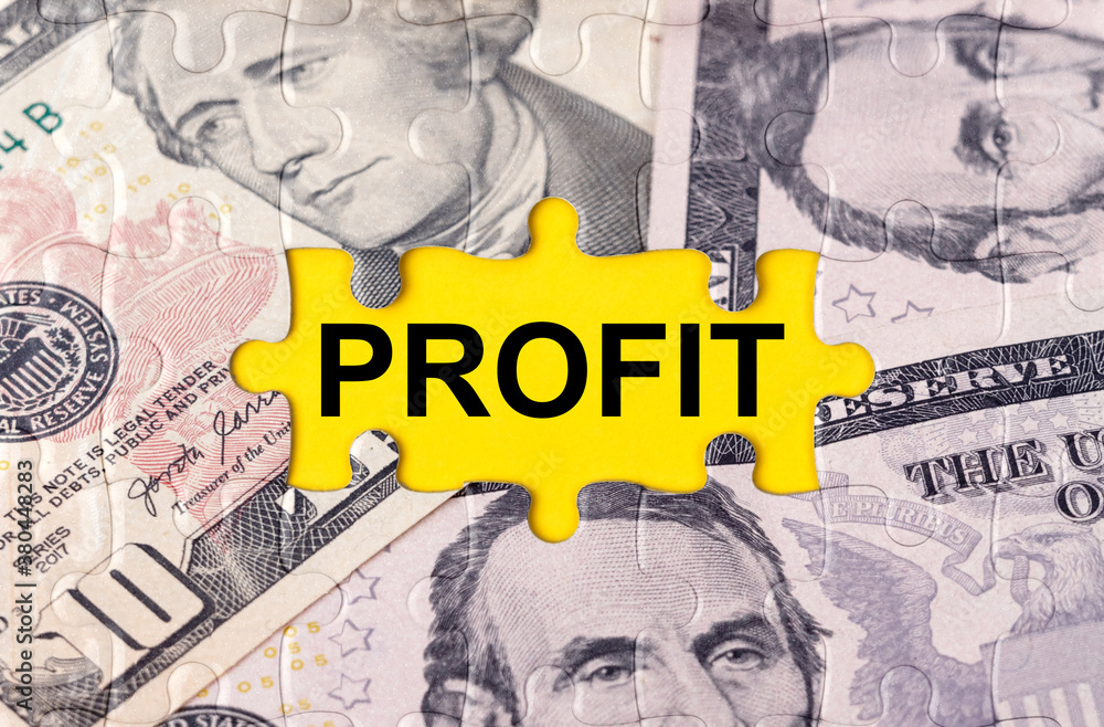 Fototapeta premium Puzzle with the image of dollars in the center of the inscription -PROFIT