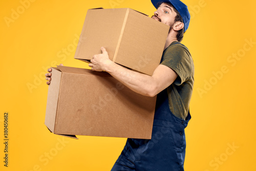 A man in a working form a box with loading tools yellow background photo