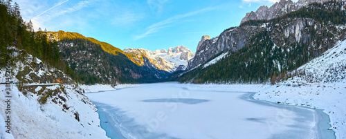 Beautiful Gosausee lake landscape with Dachstein mountains, forest, clouds and snow in Austrian Alps