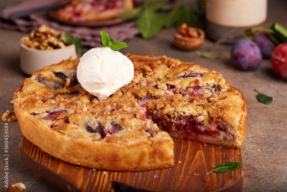 Closed pie filled with plums and walnuts. Sweet homemade dessert served with vanilla ice cream. Closed pie filled with plums and walnuts. Sweet homemade dessert served with vanilla ice cream.