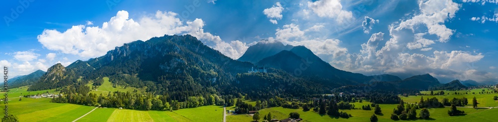 Panoramic aerial view of Neuschwanstein castle and surrounding alp mountains