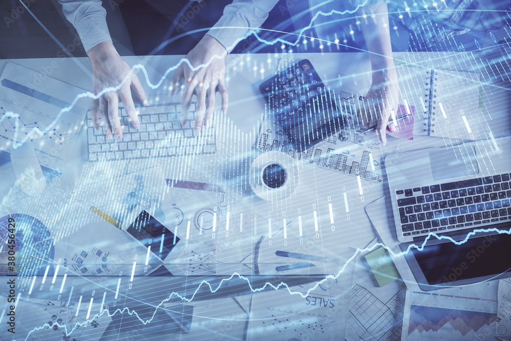 Obraz premium Double exposure of man and woman working together and financial chart hologram drawing. market analysis concept. Computer background. Top View.