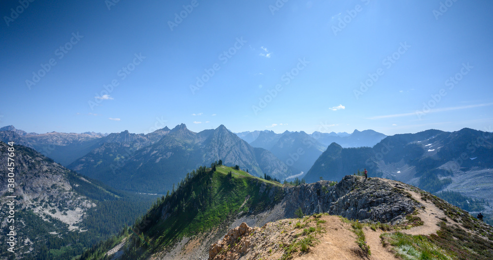 Fototapeta premium Woman Stands on Ridge of North Cascades Mountains