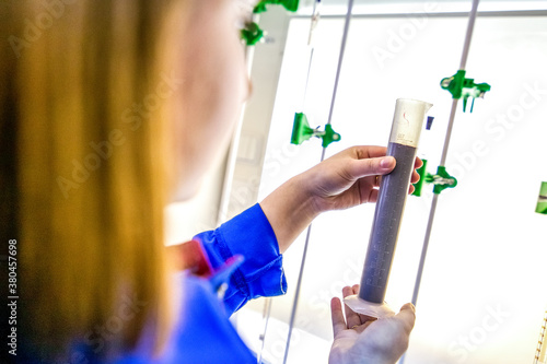 Wallpaper Mural chemist looking at test tube in the factory laboratory Torontodigital.ca