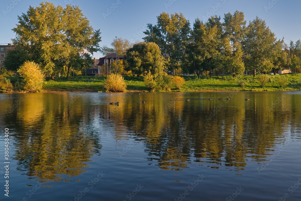 Autumn landscape in a city park on the river bank.