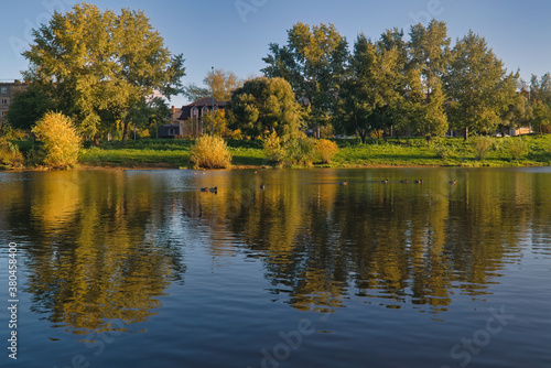 Autumn landscape in a city park on the river bank. © Anatoliy