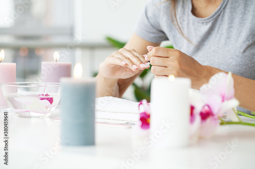 Happy pretty woman making manicure when resting at home