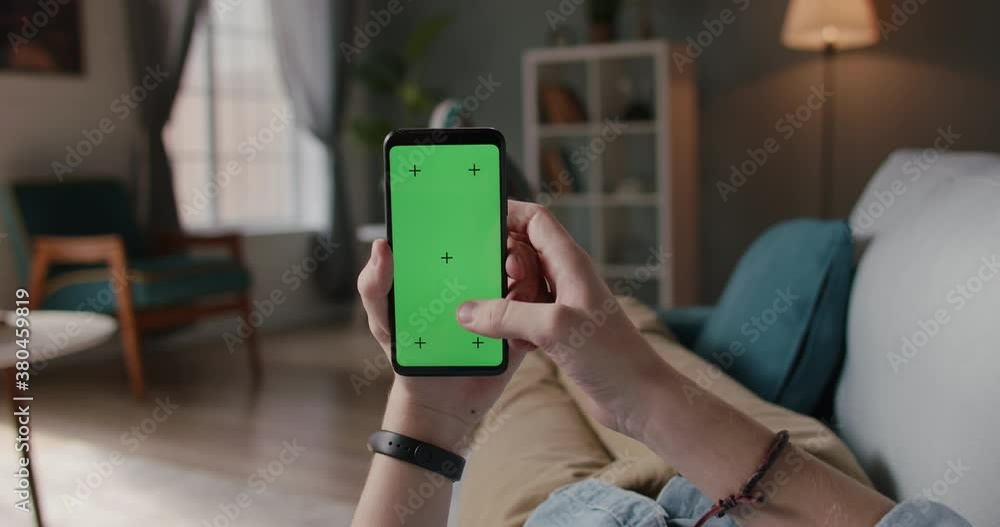 Close up shot of man lying on couch and using smart phone with chroma key green screen, doing various taps, swipes and scrolls - technology, communication 4k video template Close up shot of man lying on couch and using smart phone with chroma key green screen, doing various taps, swipes and scrolls - technology, communication 4k video template