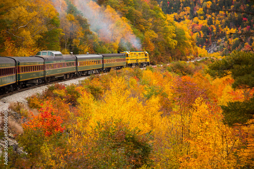 The Conway Scenic Railway train on the Crawford Notch route, just west of Bartlett, New Hampshire.  Hardwood trees are showing peak fall color in the White Mountain National Forest. photo