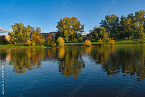 Autumn landscape in a city park on the river bank.