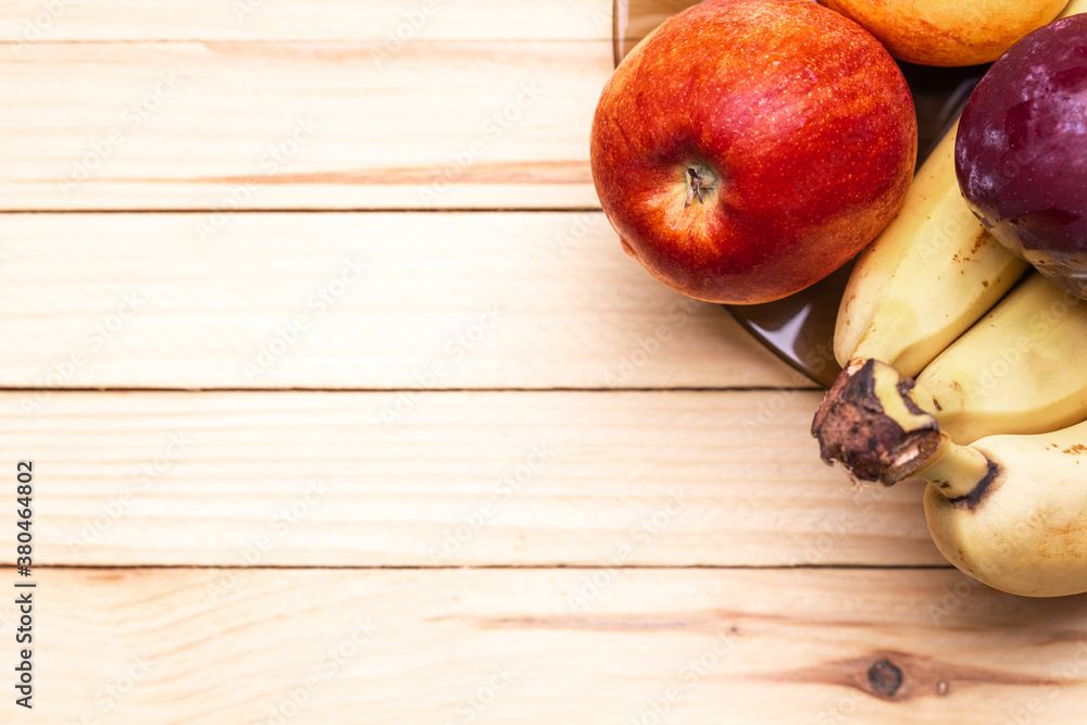 healthy eating conceptual. mixed fruits border on a wooden desk. above view. copy space. studio shot healthy eating conceptual. mixed fruits border on a wooden desk. above view. copy space. studio shot
