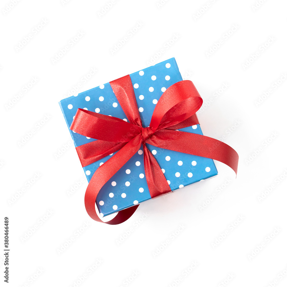 Blue polka dot gift with red ribbon on white background